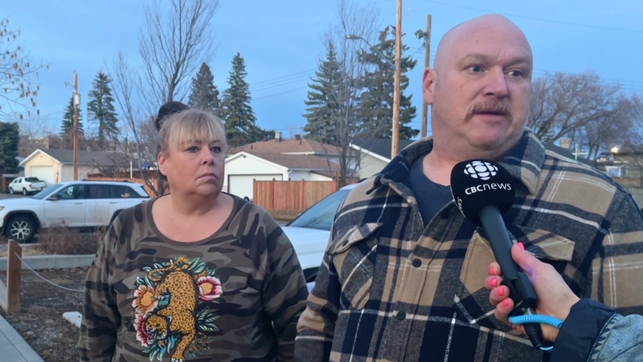 woman in sweater with tiger pattern and bald man in plaid coat