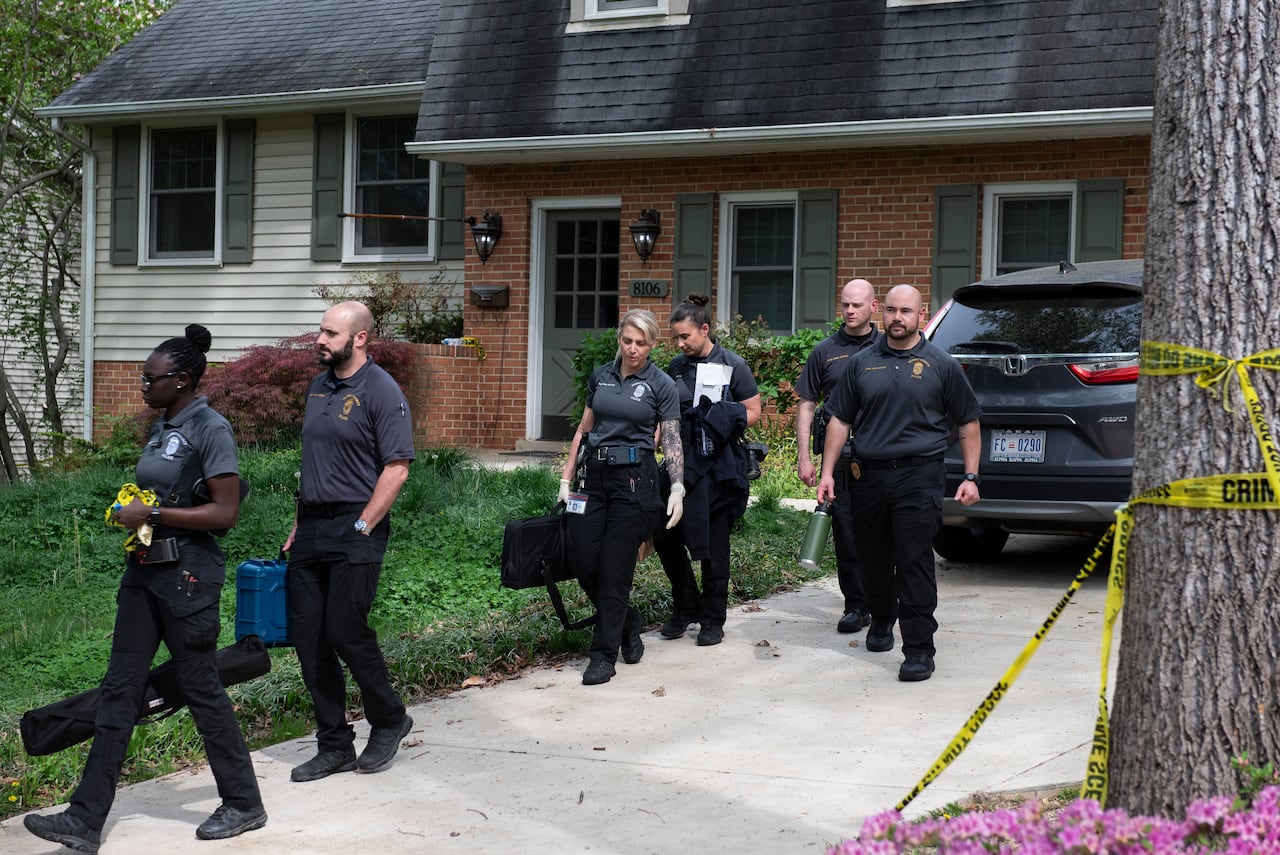 Several people in uniformed polo shirts, men and women, walk down a driveway after appaently leaving a residential home.