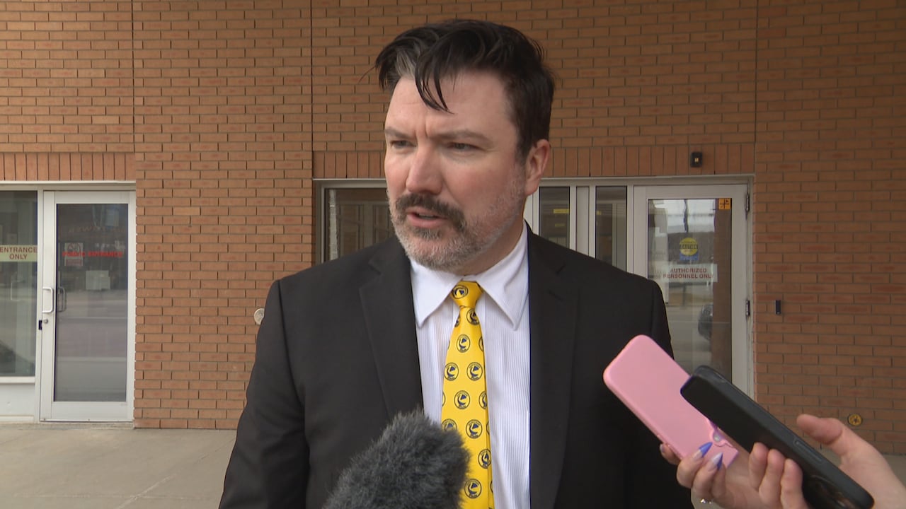 A man in a black suit with a Saskatoon Blades tie.