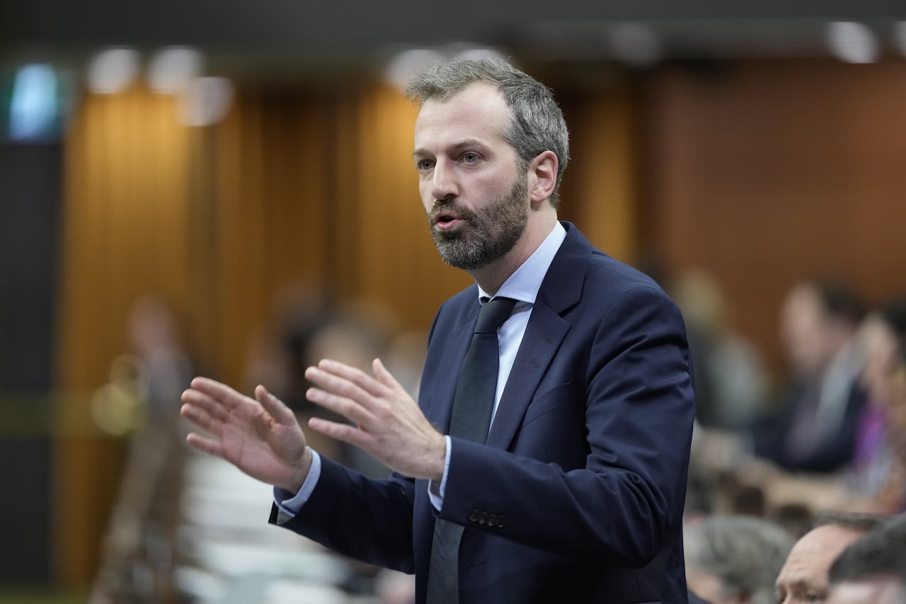A photo of a man wearing a suit speaking in the house of commons.