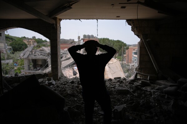 Assem Abdallah reacts as he enters his friend apartment destroyed in a Israeli airstrike in Kfar Roumman, southern Lebanon, Friday, April 17, 2026, following a ceasefire between Israel and Hezbollah. (AP Photo/Hassan Ammar)