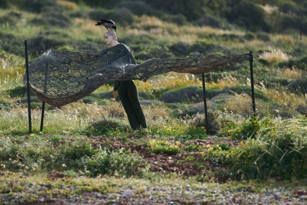 A crow sits on a the head of a mannequin with military clothing used as a decoy in northern Israel, on the border with Lebanon following a ceasefire between Israel and Hezbollah, Friday, April 17, 2026. (AP Photo/Ariel Schalit)