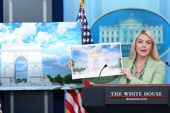 White House press secretary Karoline Leavitt holds up an artist rendering of the new triumphal arch as she speaks with reporters in the James Brady Press Briefing Room at the White House, Wednesday, April 15, 2026, in Washington. (AP Photo/Alex Brandon)