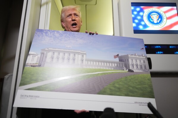 President Donald Trump holds a rendering of the proposed new East Wing of the White House as he speaks to reporters aboard Air Force One en route from West Palm Beach, Fla., to Joint Base Andrews, Md., Sunday, March 29, 2026. (AP Photo/Mark Schiefelbein)