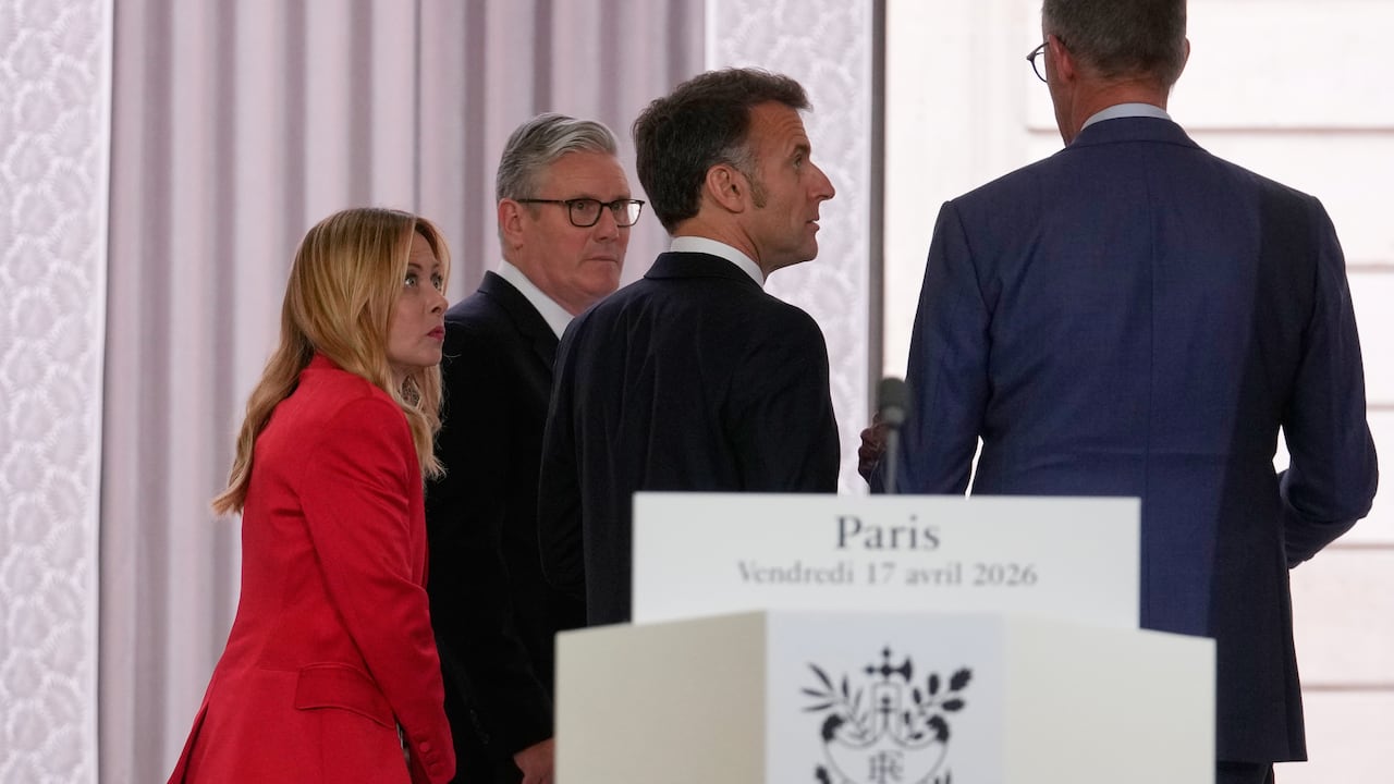 Three men and one woman walking away from a podium.