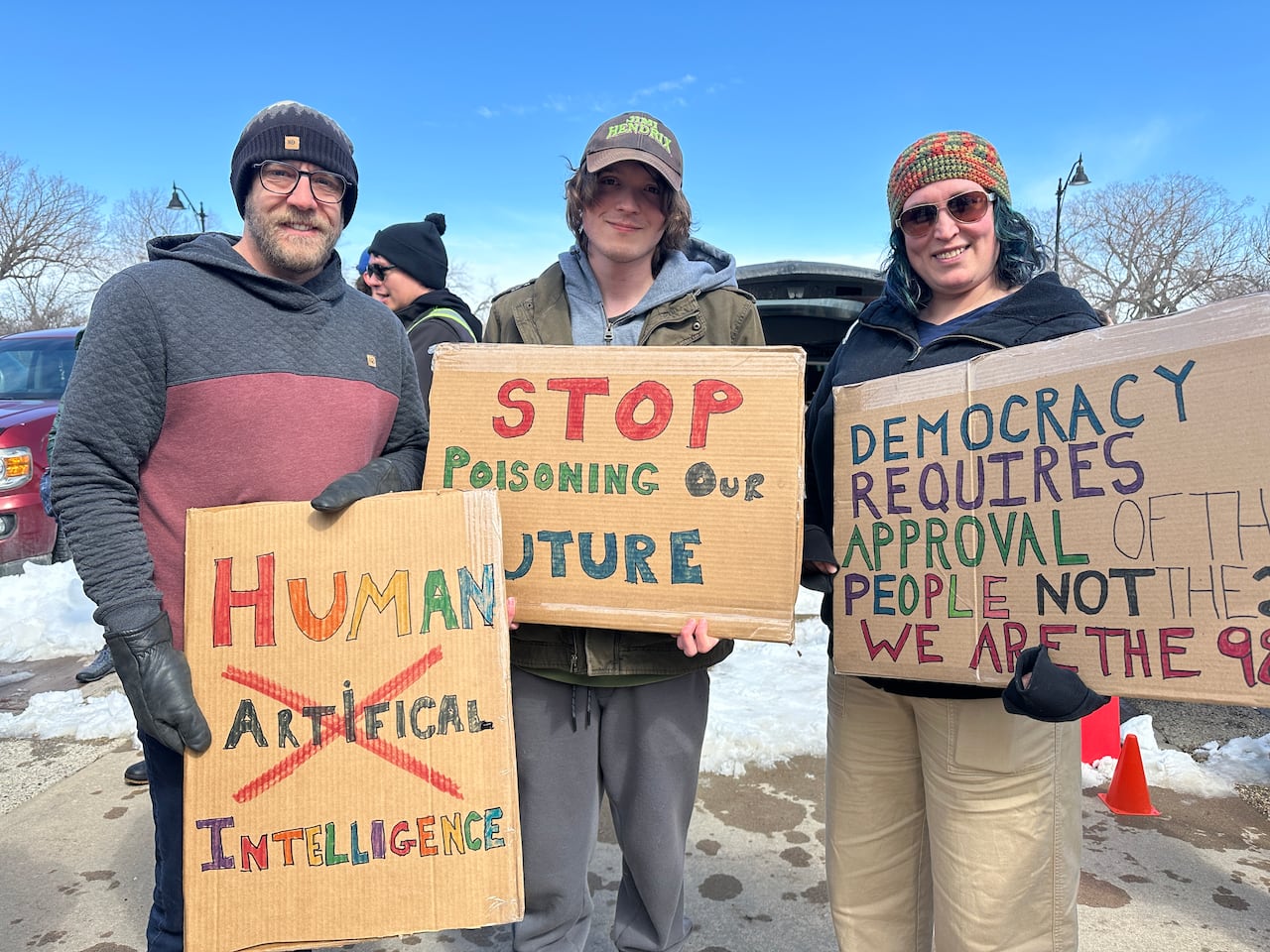A family of three all hold signs protesting AI