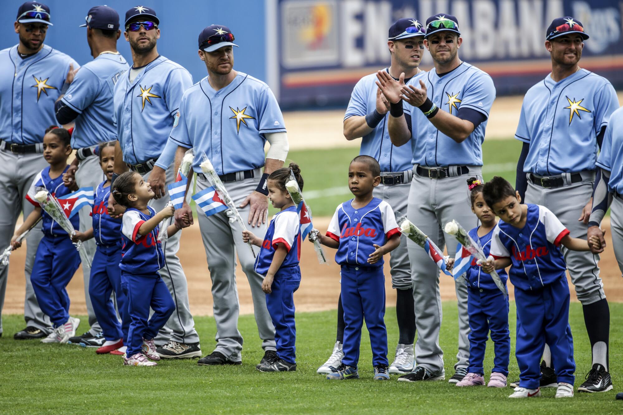 Tampa Bay Rays players with Cuban children during opening ceremonies at an exhibition baseball game.