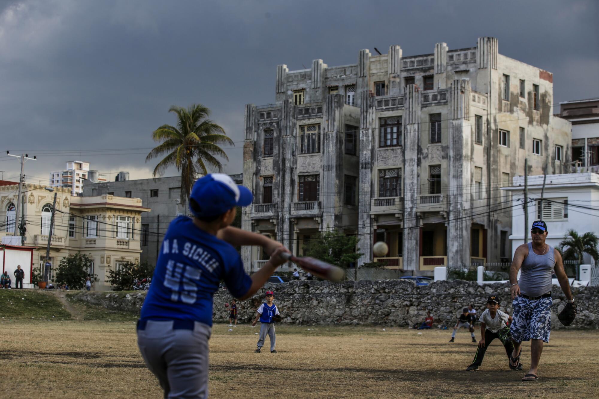 Members of the Equipo Plaza Little League team practice at a field.