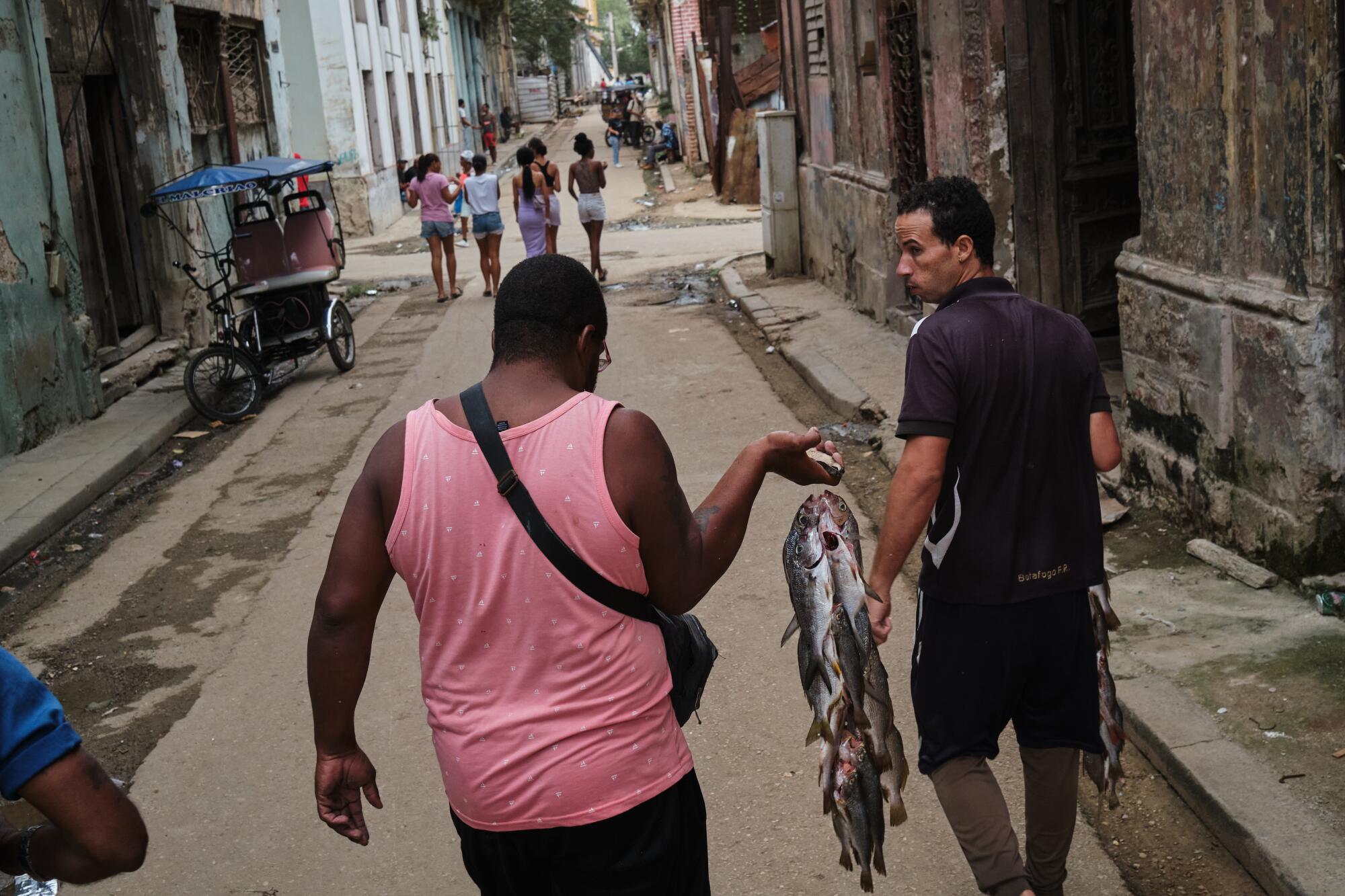 Wilfredo, a fisherman, walks through the streets of Old Havana offering his daily catch for sale.