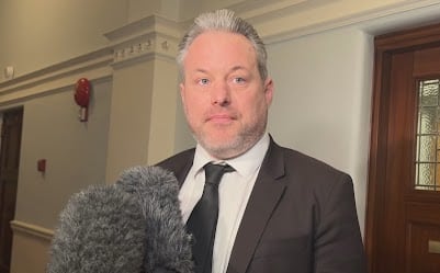 A man in a suit smiles