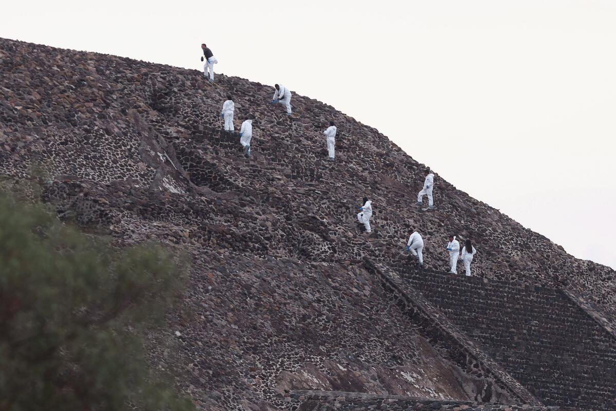 Forensic experts work on the Pyramid of the Moon following a shooting