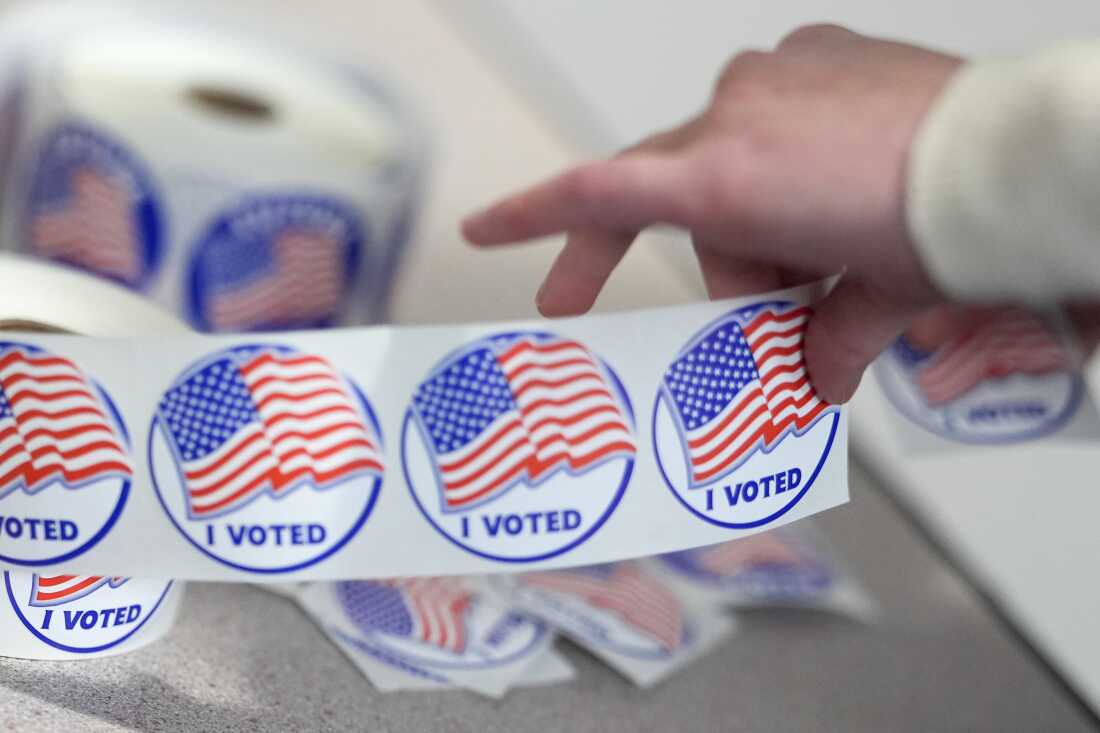 An election worker tears off "I Voted" stickers during the Virginia redistricting referendum at Fairfax Government Center, Tuesday, April 21, 2026, in Fairfax, Va. (AP Photo/Julia Demaree Nikhinson)