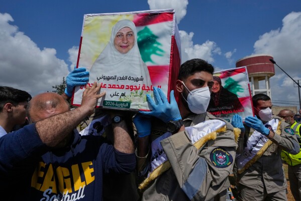 Mourners and scouts carry the coffins of civilians who were killed in the war between Hezbollah and Israel during a mass funeral in Bazouriyeh village, south Lebanon, Monday, April 20, 2026. (AP Photo/Mohammed Zaatari)