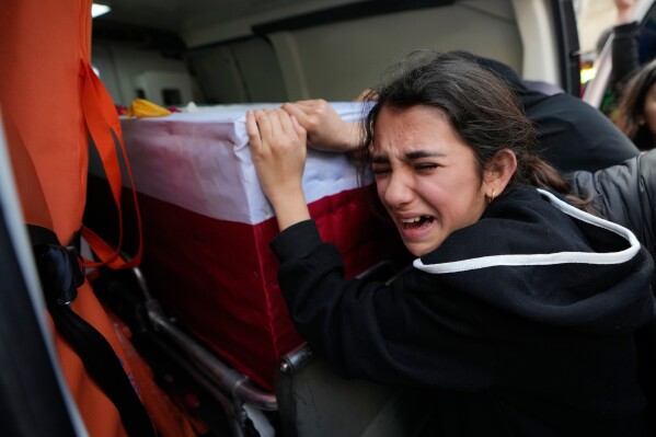 A girl mourns over the coffin of a relative who was killed in the war between Hezbollah and Israel during a mass funeral in Bazouriyeh village, south Lebanon, Monday, April 20, 2026. (AP Photo/Mohammed Zaatari)