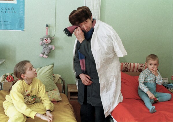 Ivan Kalenda turns away to wipe his tears as he visits his 3-year-old grandson Vitya, right, in the children's cancer hospital ward in Gomel, Belarus, March 19, 1996, nearly a decade after the explosion and fire at the Chernobyl nuclear power plant that sent radioactive clouds through Ukraine, Belarus and other parts of Europe. (AP Photo/Efrem Lukatsky, File)