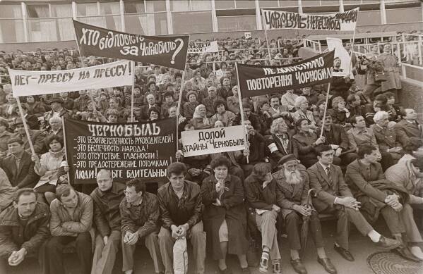 People hold signs reading "Down with the Chernobyl mysteries!" and "Who is responsible for Chernobyl?" during a protest rally demanding the truth about the Chernobyl nuclear power plant accident at a stadium in Chernobyl, Ukraine, April 26, 1989, on the third anniversary of the disaster. (AP Photo/Efrem Lukatsky)