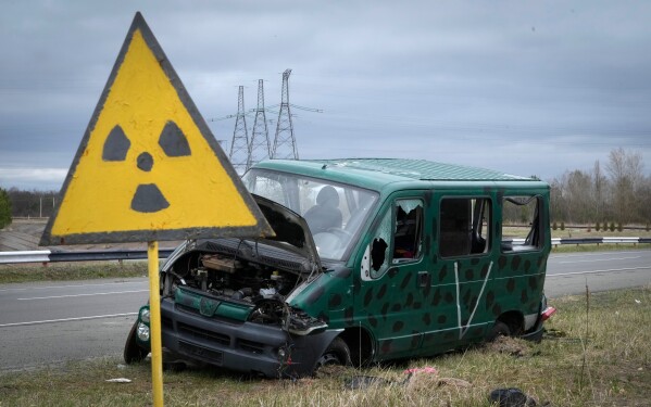 A radiation sign stands near the remains of a vehicle belonging to the Russian military near the Chernobyl nuclear power plant in Chernobyl, Ukraine, April 16, 2022. (AP Photo/Efrem Lukatsky, File)