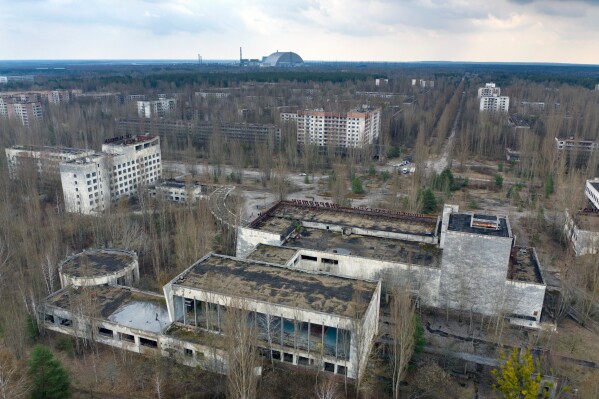 A dome-shaped shelter covering the damaged reactor at the Chernobyl nuclear plant is seen on the horizon, April 15, 2021, from the abandoned town of Pripyat, Ukraine, once home to some 50,000 people whose lives were connected to the plant. (AP Photo/Efrem Lukatsky, File)
