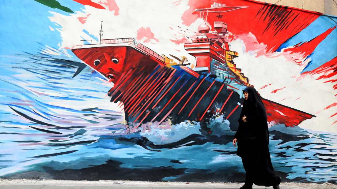 A woman walks past an anti-U.S. and anti-Israel mural in Tehran on Tuesday.