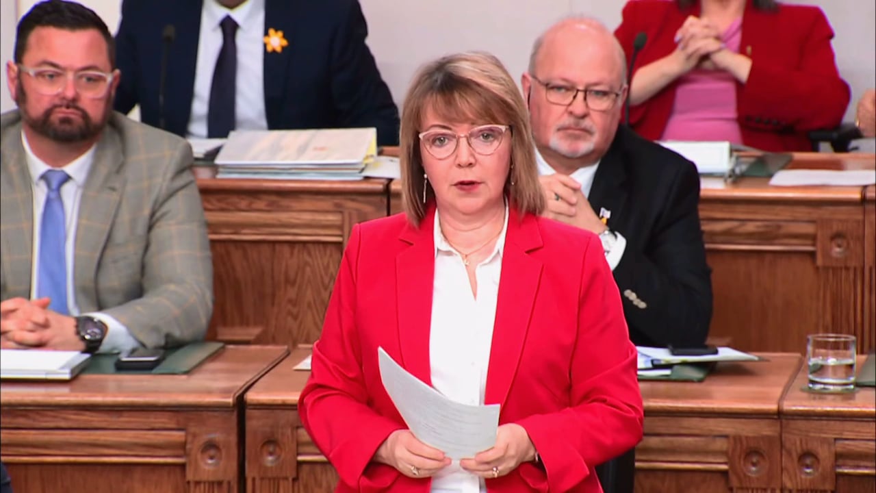 A woman in a red blazer.