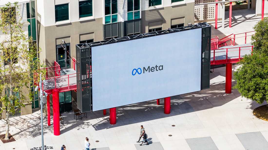 Workers walk past a display at Meta headquarters on Thursday, March 26, 2026, in Menlo Park, Calif.
