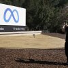 Facebook employee take a photo in front of new Meta Platforms Inc. sign outside the company headquarters in Menlo Park, Calif., Thursday, Oct. 28, 2021.