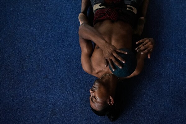 A player stretches prior to a match during an ulama championship, a traditional ballgame with roots in Mesoamerican culture, in Mexico City, Sunday, April 19, 2026. (AP Photo/Fernando Llano)