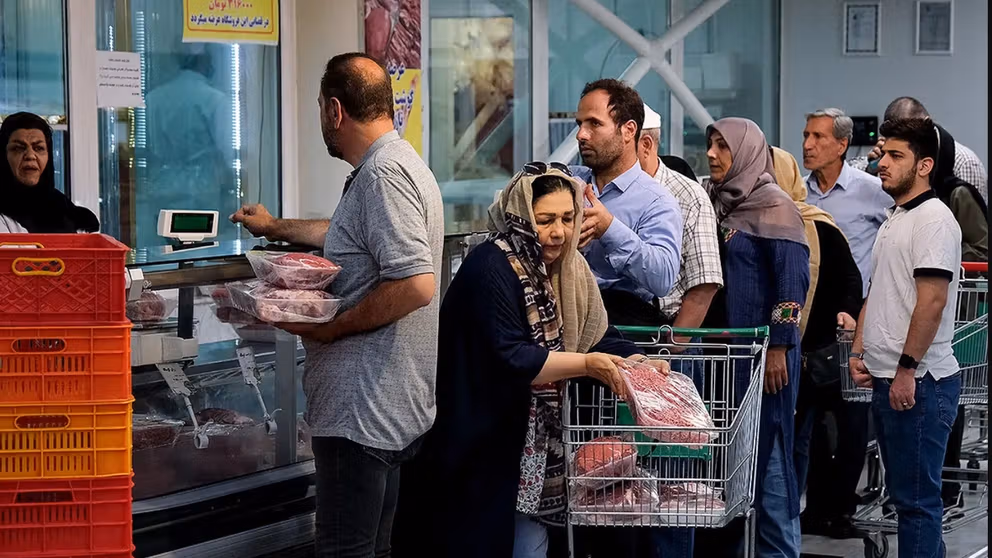 Shoppers queue at a butcher’s counter in Iran as food costs continue to climb.