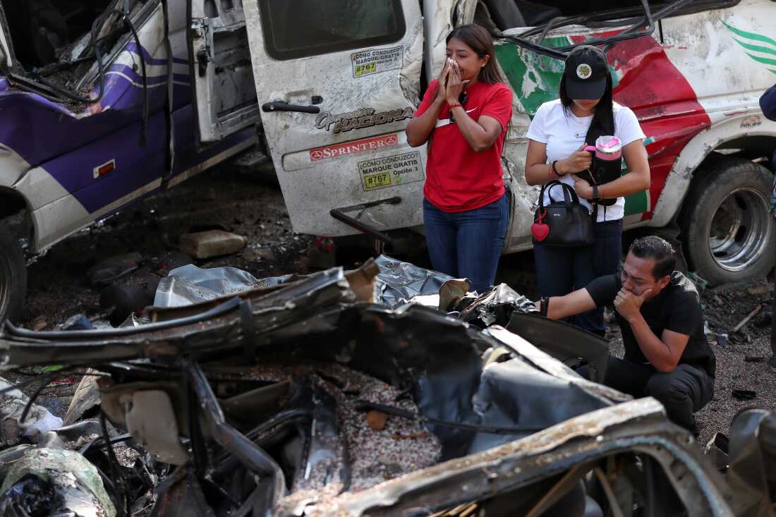Relatives of victims pay respects at the site of an attack on the Pan-American Highway in Cajibio, Colombia, Sunday, April 26, 2026, where at least a dozen people were killed in an attack authorities blamed on dissident groups of the former FARC rebels.