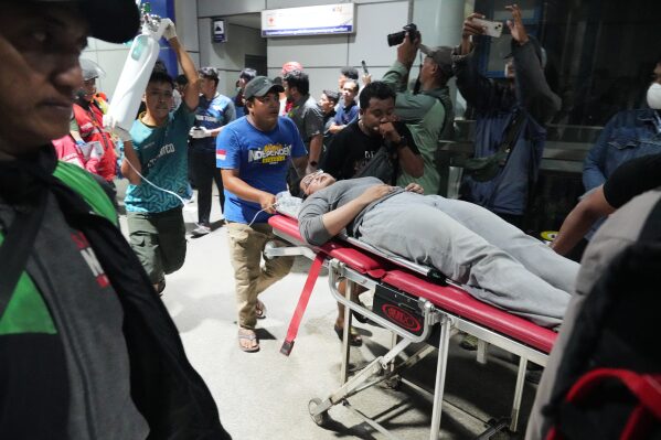 People push a woman on a stretcher following a train collision in Bekasi, Indonesia, Monday, April 27, 2026. (AP Photo/Achmad Ibrahim)