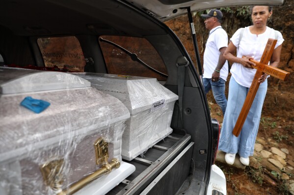 Coffins containing the remains of victims killed in an attack on the Pan-American Highway that authorities blamed on dissident former FARC rebels, sit in a hearse to be transported to the cemetery in Cajibio, Colombia, Tuesday, April 28, 2026. (AP Photo/Santiago Saldarriaga)