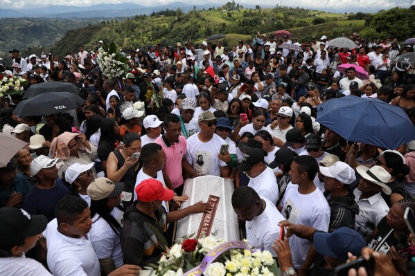 Relatives mourn during a burial service for victims who were killed in an attack on the Pan-American Highway that authorities blamed on dissident former FARC rebels, at the cemetery in Cajibio, Colombia, Tuesday, April 28, 2026. (AP Photo/Santiago Saldarriaga)