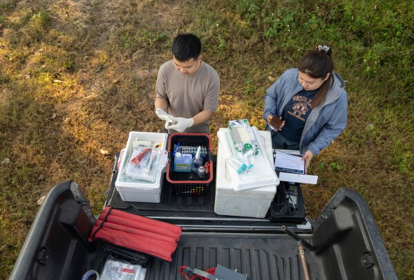 Researchers Khanasuan Kaeothip, left, and Warakorn Maneechuket prepare to take samples from the Kok River in Chiang Saen, Thailand, Tuesday, Feb. 17, 2026. (AP Photo/Anton L. Delgado)