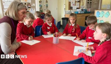 Undercover footage of a man in a suit, wearing glasses, in a hotel lobby.