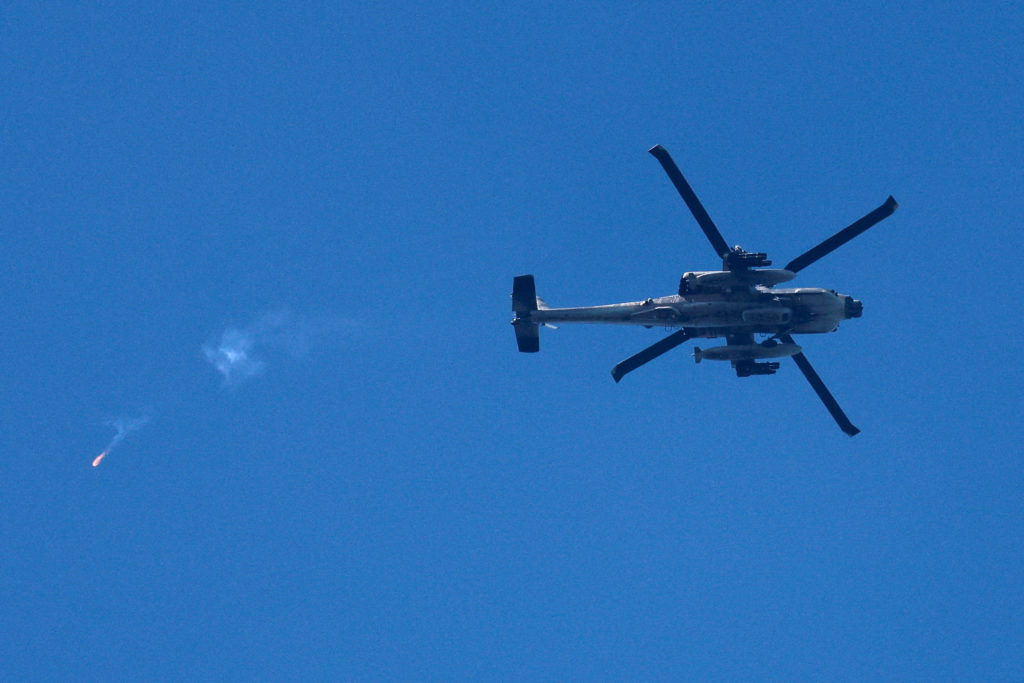 An Israeli Apache helicopter releases a flare as it flies over the border with Lebanon