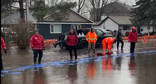 Volunteers, city staff working amid downpour to stem floodwaters