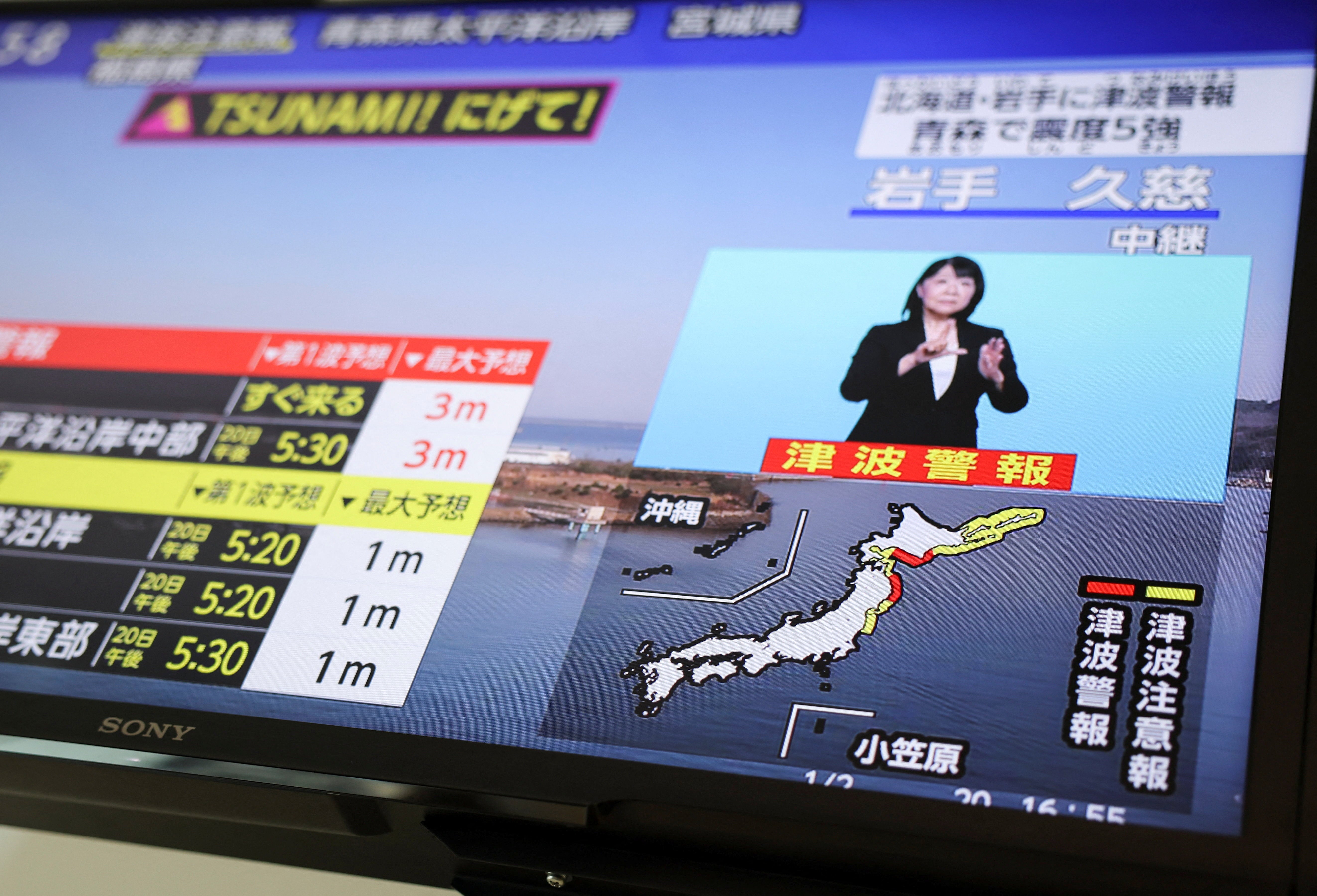 A television screen shows a news report on Japan Meteorological Agency's tsunami warning, saying it expected tsunami waves of up to 3 meters (9.84 feet) to reach large coastal areas in northern Japan after an earthquake with a preliminary magnitude of 7.4 struck off the northeastern coast of Japan