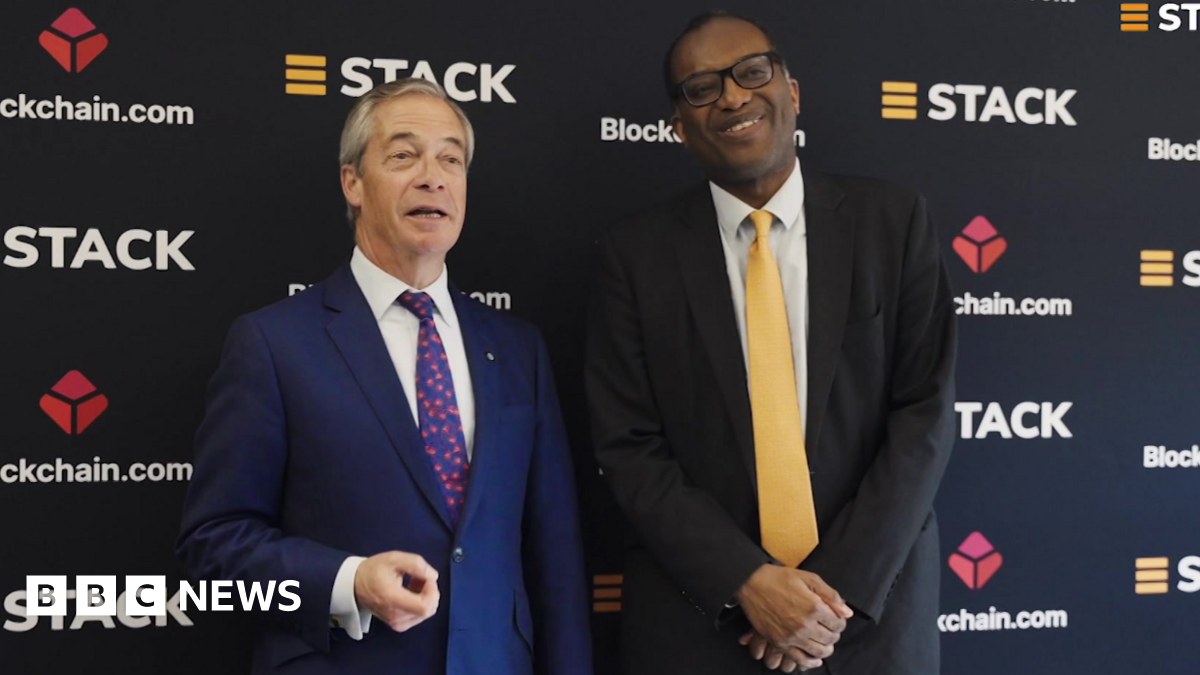 Reform UK leader Nigel Farage (L) stands with former Chancellor Kwasi Kwarteng (R) as they promote cryptocurrency. Farage wears a dark blue suit, a white shirt and a blue tie with red blossoms. Kwarteng wears a black suit,  a white shirt and a butter yellow tie.