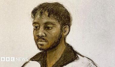 A drawing of a young man by a court room artist. He has short black hair and is wearing an open-necked dark shirt.
