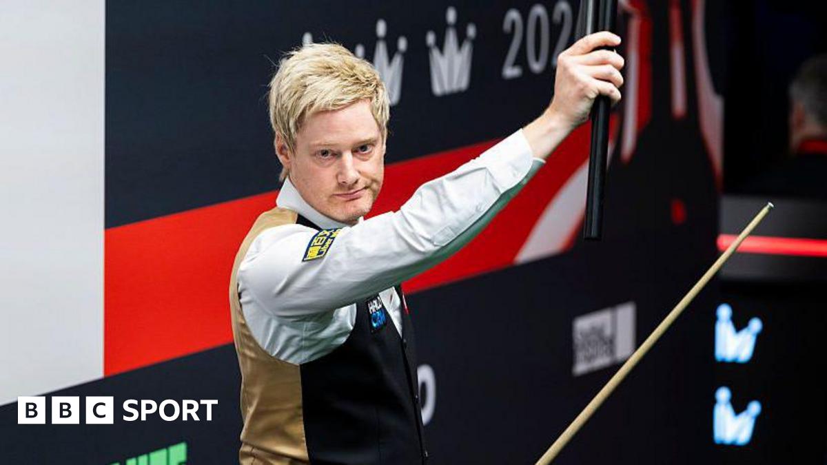 Neil Robertson holds his cue extension aloft