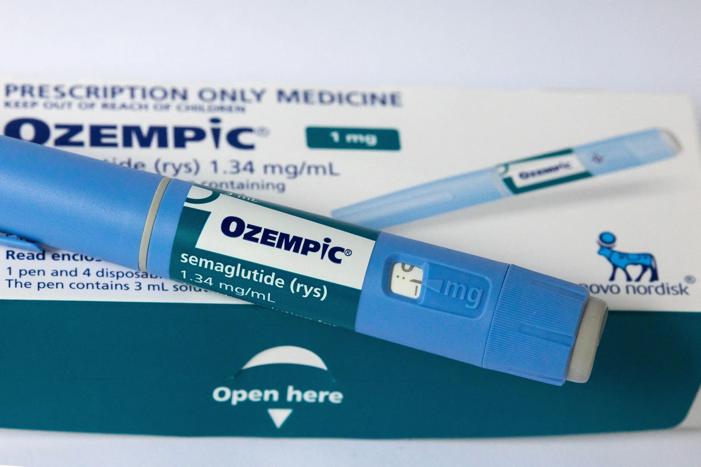 An Ozempic semaglutide injection pen (1mg) resting on its packaging.