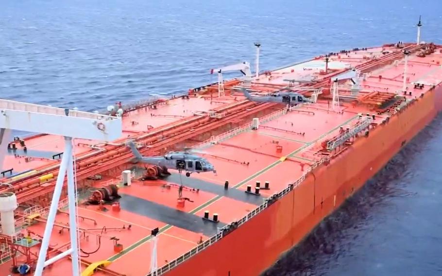 U.S. troops rappel from helicopters onto the deck of an oil tanker.
