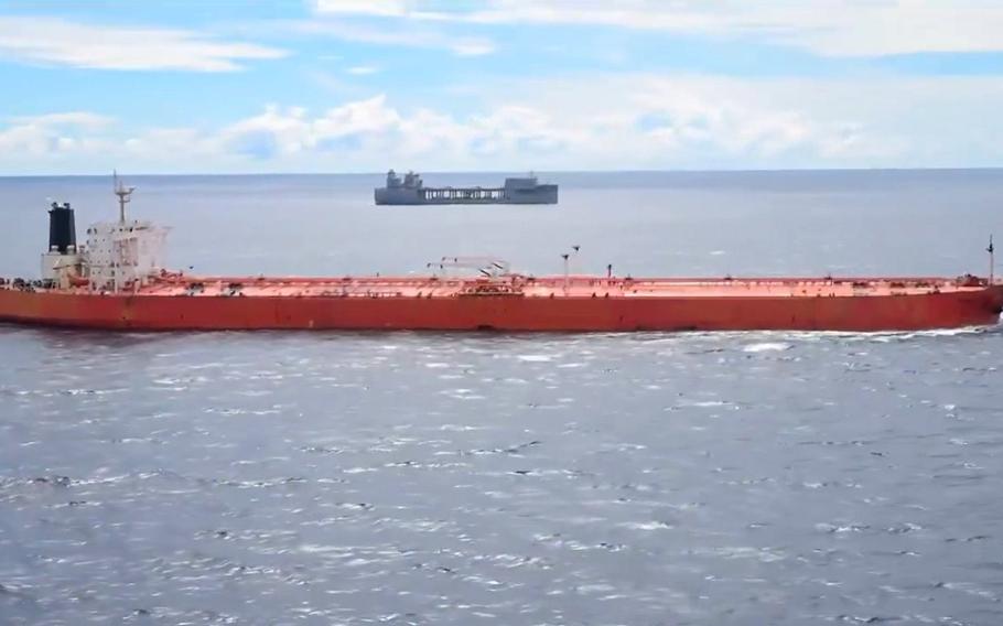 An oil tanker is seen in the ocean near a U.S. Navy ship.