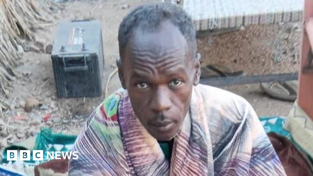 Mohamed Suleiman looks up at the camera, he has a blanket around his shoulders.