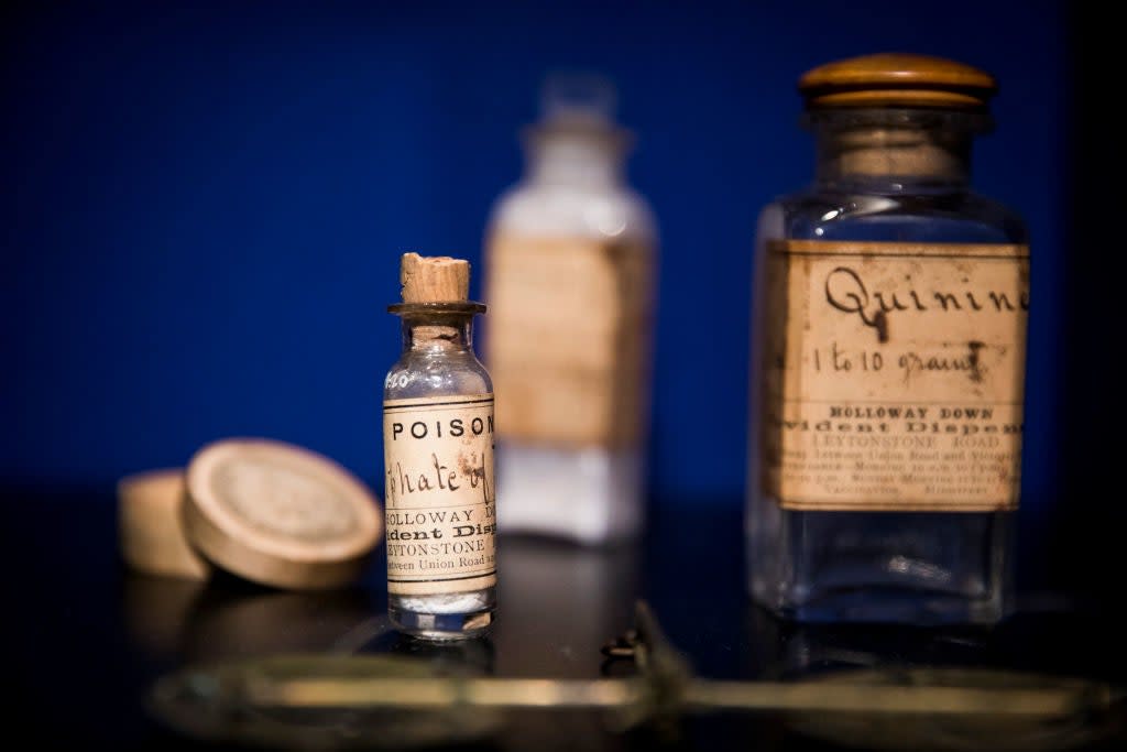 Vintage medicine bottles with labels like "Poison" and "Quinine" on a table, suggesting historical remedies