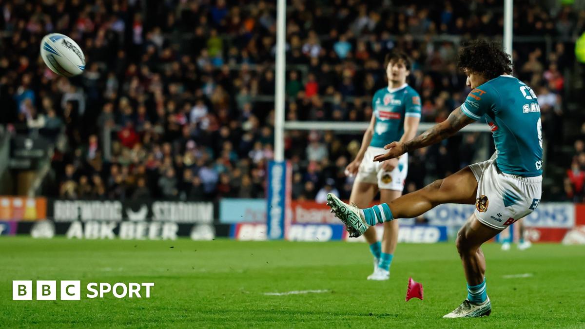 St Helens full-back Tristan Sailor (right, in green shirt and white shorts) kicks for goal against Catalans Dragons with a team-mate watching in the background.