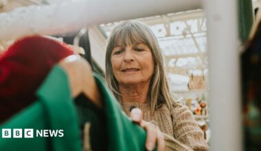 Woman looks at a rack of clothes in a market.