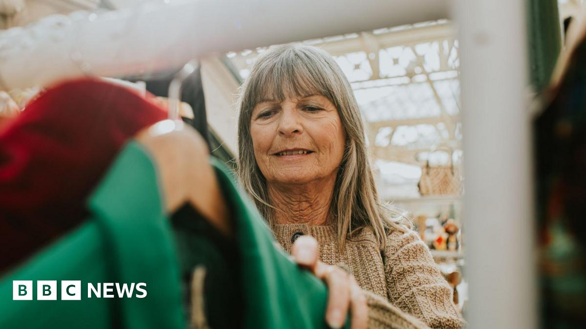Woman looks at a rack of clothes in a market.
