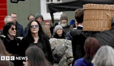 Shows Enya and other mourners at the funeral