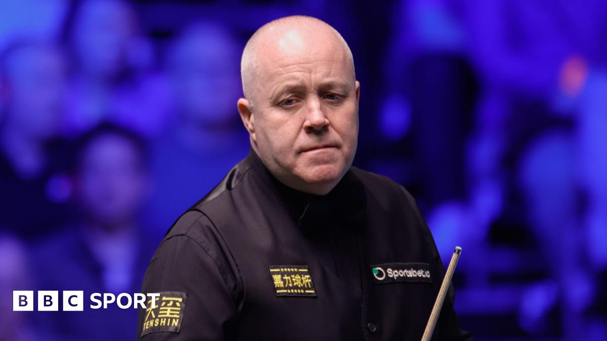 John Higgins holding a cue at the Tour Championship